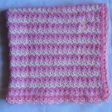 Manta rosa con diseño líneas para bebé a crochet